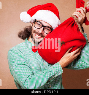 Mann hält ein Geschenk und emotional Frohe Weihnachten Stockfoto