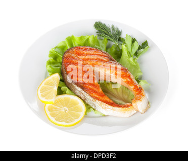 Gegrillter Lachs mit Zitronenscheiben und Kräutern auf Platte. Isoliert auf weißem Hintergrund Stockfoto