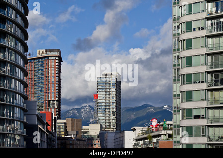 Hochhäuser von Downtown Vancouver mit den North Shore Mountains in der Ferne.  Weihnachtsschmuck angezeigt. Stockfoto