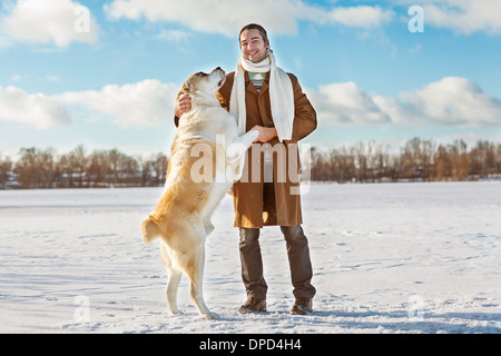 Mann und zentralasiatischen shepherd spielen mit seinem Hund im freien Stockfoto