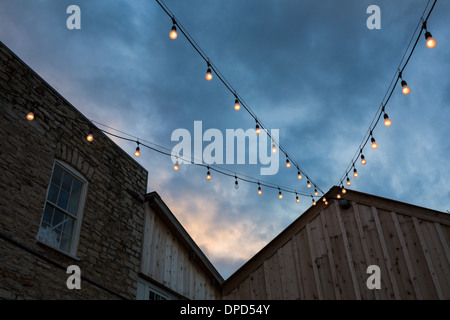 Dramatischen Sonnenuntergang über ein rustikal, Landhausstil, bauen mit Lichterkette Stockfoto