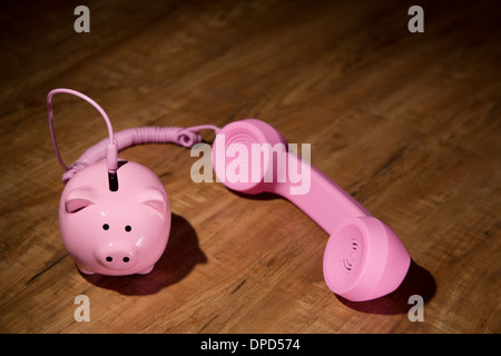 Hilferuf mit Einsparungen - ein Sparschwein und einen Telefonhörer Stockfoto