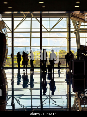 Silhouetten von unkenntlich reisen Menschen am Flughafen vor riesige Fenster mit Naturlandschaft im Hintergrund Stockfoto