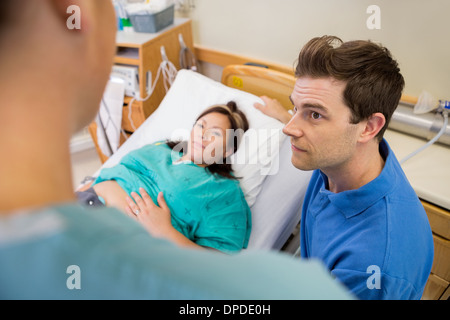 Mann und schwangere Frau anhören Krankenschwester im Krankenhaus Stockfoto