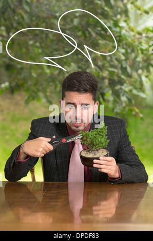 Mann-trimmen-Bonsai-Baum in einem Topf Stockfoto