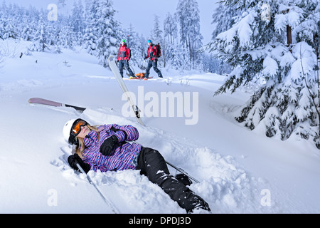 Skifahrer nach Unfall für Bergrettung im Schnee liegend Stockfoto
