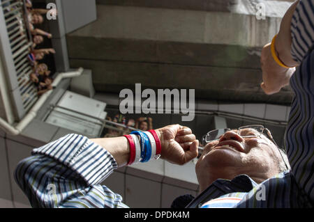 Innenstadt von Bangkok, Thailand. 13. Januar 2014. Thailändische Oppositionsführer Suthep Thaugsuban macht einen Rundgang auf dem Weg auf die Bühne, wo Tausende seiner Anhänger bereits erwarten ihn in der Innenstadt von Bangkok, Thailand, 13. Januar 2014. Tausende von Gegnern der aktuellen thailändischen Regierung haben teilweise Geschäftsleben in der thailändischen Hauptstadt gestoppt. Sie besetzten mindestens sieben wichtige Kreuzungen. Foto: Sebastian Backhaus/Dpa - Achtung! KEIN Kabel-SERVICE-/ Dpa/Alamy Live News Stockfoto