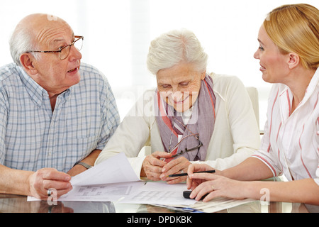Paar von Seniorinnen und Senioren, Finanzberater über ihre Rente zu sprechen Stockfoto