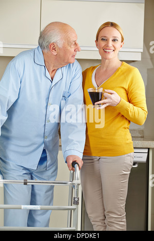 Frau mit älteren Mann und seine Walker in der Küche Stockfoto