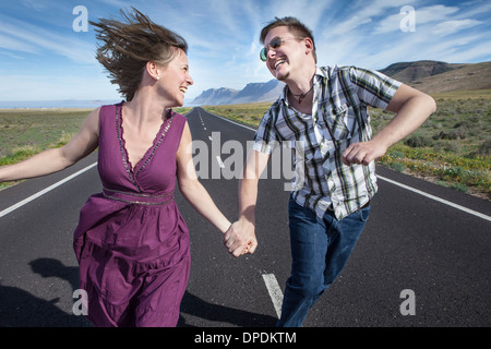 Mitte erwachsenes paar auf der Straße laufen Hand in Hand, Lanzarote, Spanien Stockfoto