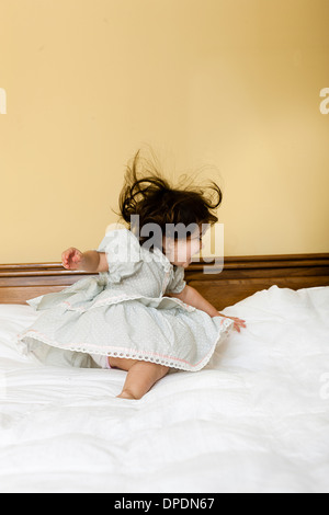 Babymädchen unsicher auf Bett Stockfoto