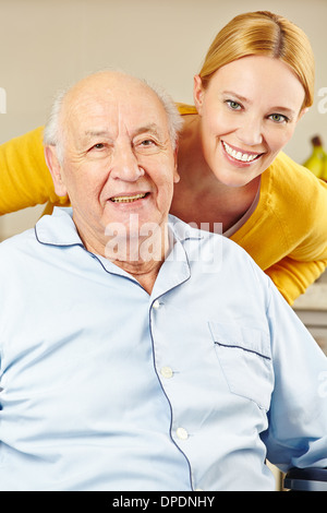 Frau und Alter Mann im Rollstuhl lächelnd zusammen Stockfoto