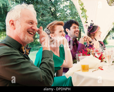 Frisch verheiratetes Paar mit Eltern bei Hochzeitsfeier Stockfoto