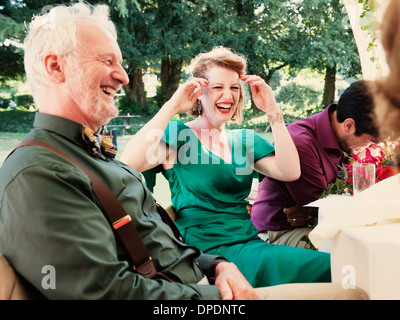 Frisch verheiratetes Paar mit Eltern lachen bei Hochzeitsfeier Stockfoto