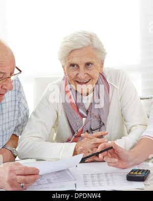 Älteres Paar, die Diskussion über ihre finanzielle Situation mit Rechnungen auf dem Tisch Stockfoto