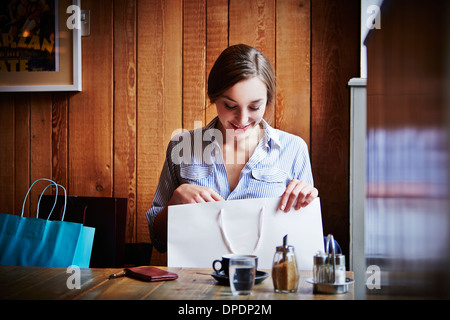 Junge Frau sitzt im Café suchen Warenkorb ist leer Stockfoto