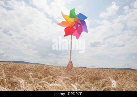 Hand halten Windmühle im Weizenfeld Stockfoto