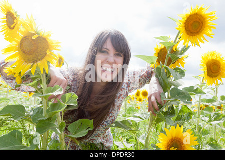 Mitte Erwachsene Frau im Feld von Sonnenblumen Stockfoto