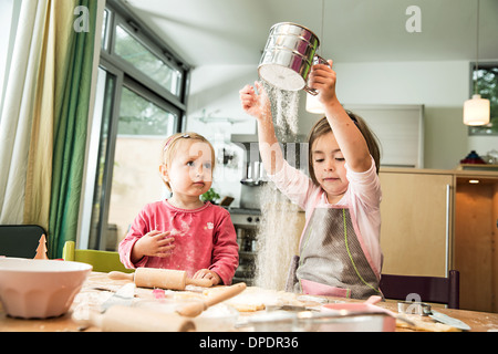 Mädchen, die Siebung Mehl in Küche Stockfoto