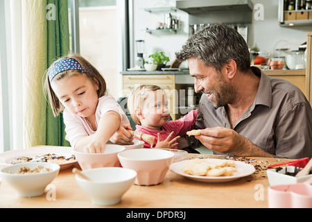 Vater und Kinder backen in der Küche Stockfoto