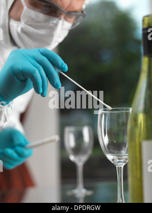 Forensische Wissenschaftler mit einem DNA-Tupfer, Beweise aus einem Glas bei der Szene des Verbrechens Stockfoto