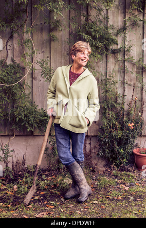 Porträt von Reife Frau stützte sich auf Spaten im Garten Stockfoto