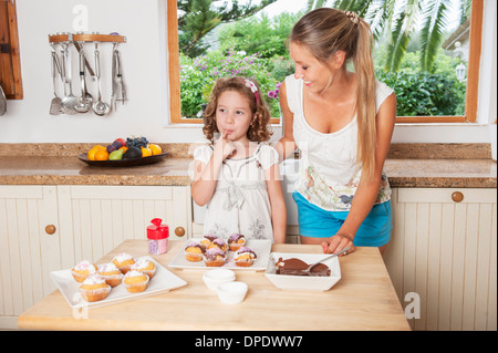 Mutter und Tochter Muffins dekorieren Stockfoto