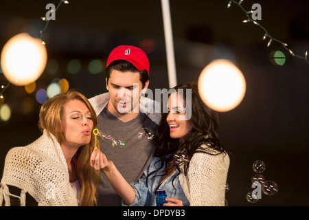 Jungen Erwachsenen Freunden herumalbern Seifenblasen auf Party auf dem Dach Stockfoto