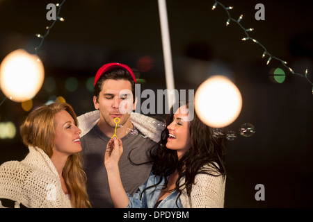 Junge Erwachsene Freunde Seifenblasen auf Party auf dem Dach Stockfoto