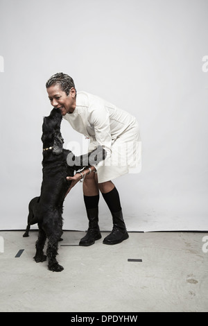 Studioaufnahme von Reife Frau, die Spaß mit Hunden Stockfoto