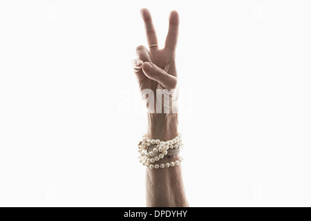 Studioaufnahme von Reife Frau Hand Frieden Geste Stockfoto