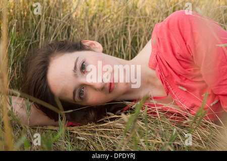 Porträt der jungen Frau liegt auf dem Rasen Stockfoto