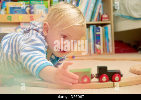 Baby Junge spielt mit Eisenbahn-set Stockfoto