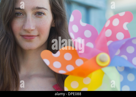 Porträt der jungen Frau, die mit Papier Windmühle Stockfoto