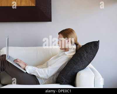 Junge Geschäftsfrau mit Laptop im Hotelzimmer Stockfoto