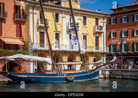 Segelboot in den kleinen Hafen in Malcesine am Gardasee, Lombardei, Italien Stockfoto