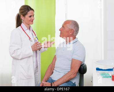 Ärztin im Gespräch mit älteren männlichen Patienten Stockfoto