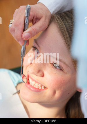 Zahnarzt mit Mundspiegel auf Teenager-Mädchen Stockfoto