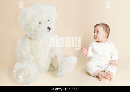 Studio-Porträt des Mädchens neben riesigen Teddybär Stockfoto