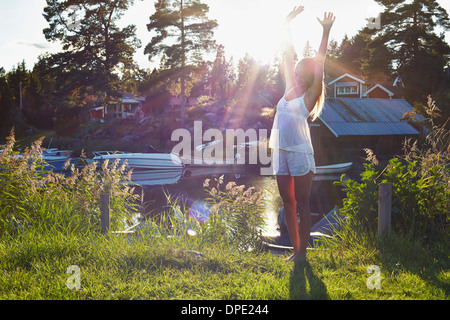 Junge Frau tanzt am See, Hotels, Schweden Stockfoto