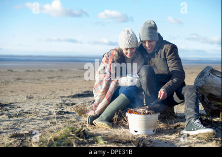 Junges Paar mit Bbq am Strand, Brean Sands, Somerset, England Stockfoto
