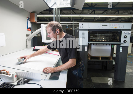 Arbeiter, die Vorbereitung von digitalen Druckmaschinen in Druckwerkstatt Stockfoto