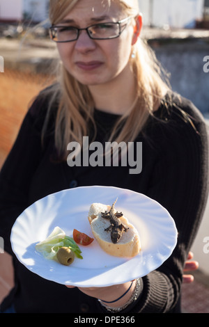 Angewidert Frau mit Eidechse auf dem Teller. Stockfoto