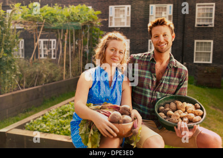 Paar mit geernteten Kartoffeln und Rüben auf Sozialsiedlung Zuteilung Stockfoto