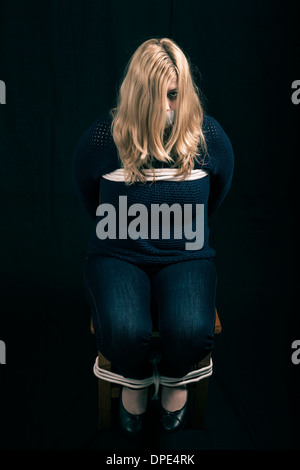 Frau als Geisel mit Klebeband den Mund entführt und mit Seilen gefesselt Stockfoto