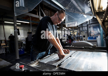 Arbeiter, die Druckmaschine in Werkstatt Service Stockfoto