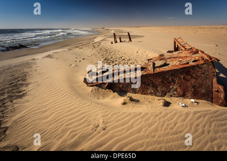 Nahaufnahme des rostigen Rumpfes eines im Sand vergrabenen Frachtschiffes am Strand von Skeleton Coast. Stockfoto