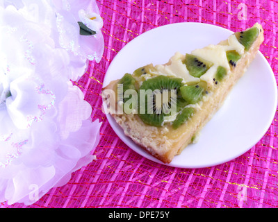 Kiwi lecker Kuchen auf Teller mit weißen Blüten Nahaufnahme Stockfoto