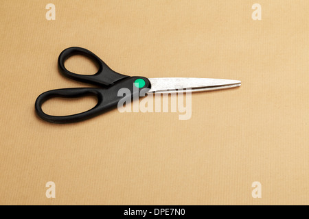 Eine schwarze Schneiderin Schere auf einem Hintergrund von einem Geschenkpapier Stockfoto