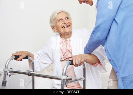 Krankenschwester hilft Senioren Patienten im Pflegeheim aufstehen Stockfoto